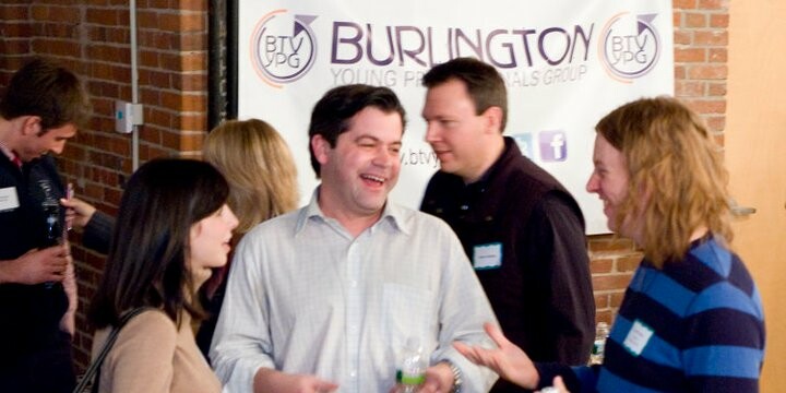 Group of professionals mingling at a Burlington event, smiling and chatting.
