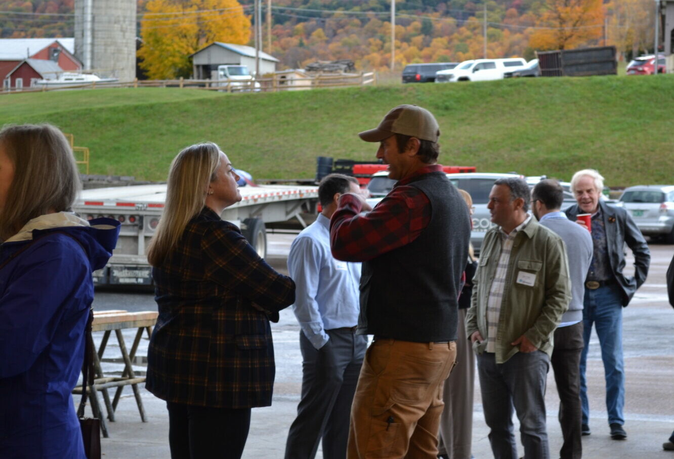 Business professionals networking at an outdoor LCC event in Vermont during peak fall foliage season.