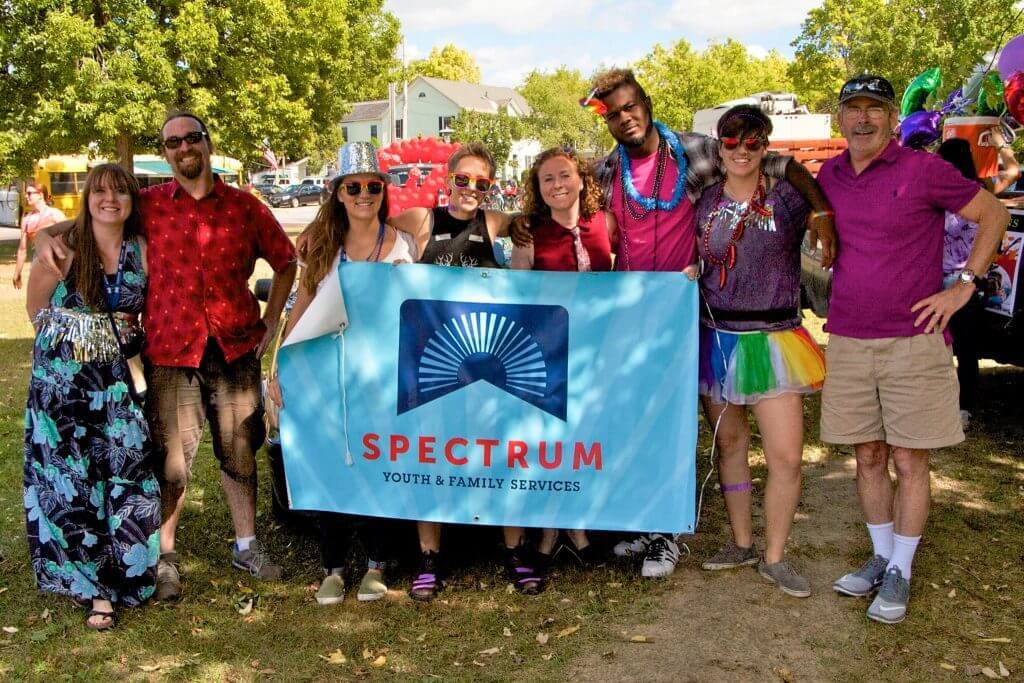 Group of people holding a Spectrum Youth & Family Center sign