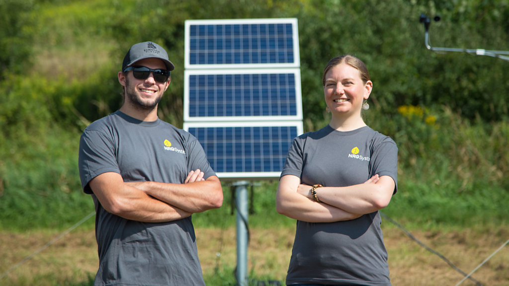 Two people standing in front of solar panel
