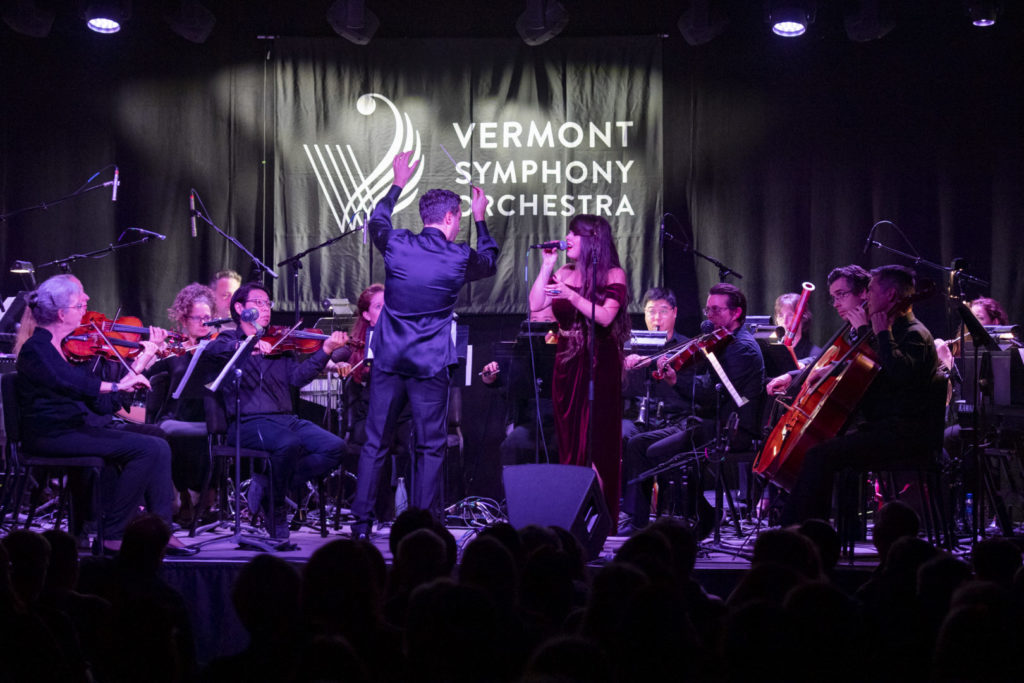 photo of vermont symphony orchestra playing on stage with woman singing into microphone