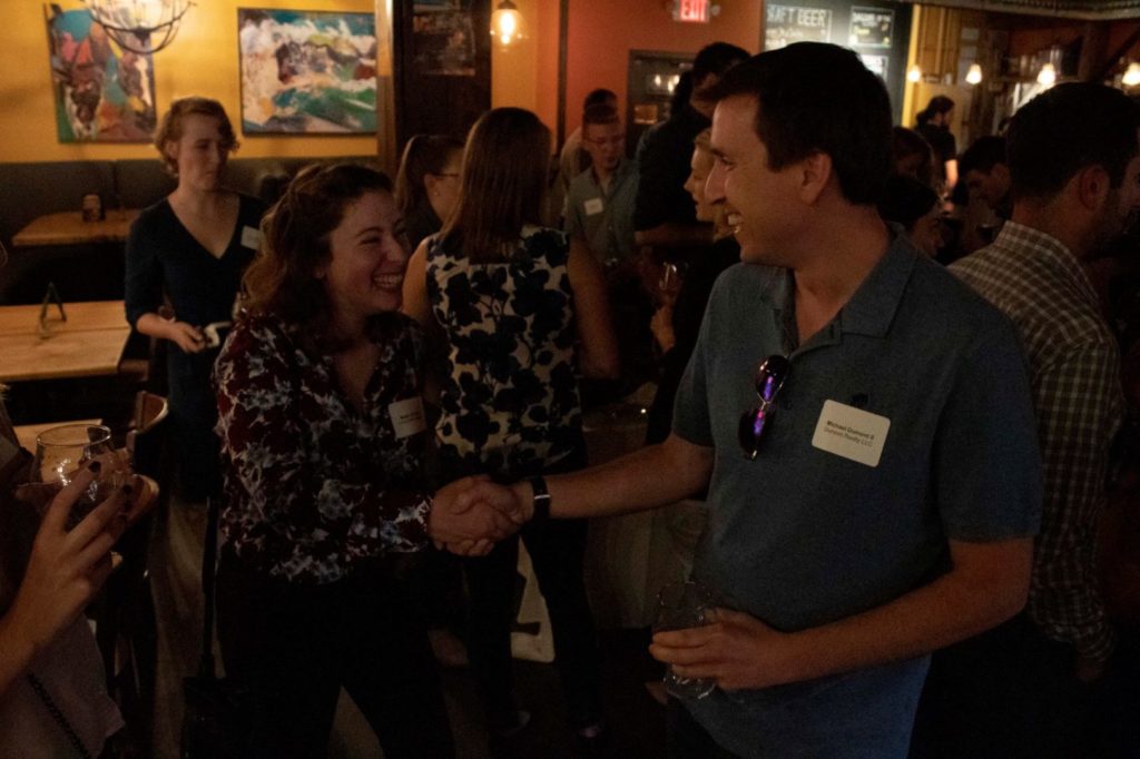photo of two young professionals shaking hands and wearing nametags at recent byp event